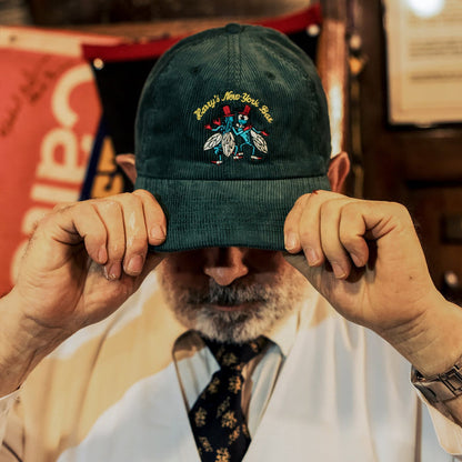Dark green corduroy dad hat satin-stitched with Harry's famous bar flies motif.